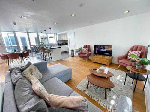 a living room with a couch and a table at Modern 3-Bedroom flat in Holloway with Private Patio near Islington, Caledonian Road, Emirates Stadium by Staylio Ltd in London
