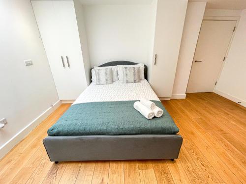 a bedroom with a bed with two towels on it at Modern 3-Bedroom flat in Holloway with Private Patio near Islington, Caledonian Road, Emirates Stadium by Staylio Ltd in London