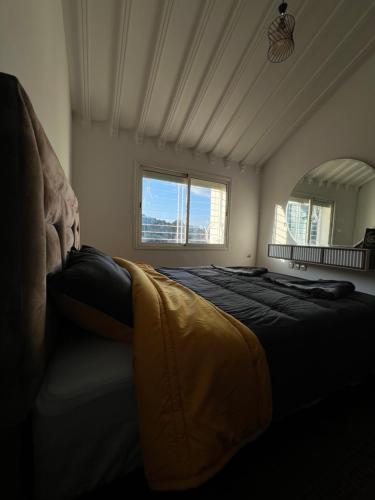 Un dormitorio con una cama grande con una manta amarilla. en Chalet cosy familial à Imouzzer - calme, nature et confort, en Imouzzer Kandar