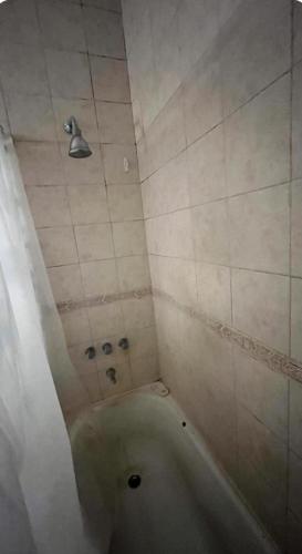 Casa Chauvin con pileta في مار ديل بلاتا: حمام مع حوض استحمام مع رأس دش