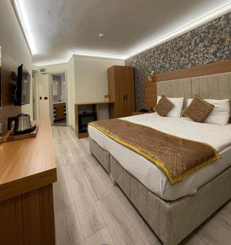 a hotel room with a large bed and a television at Golden Lux Hotel Antalya in Antalya