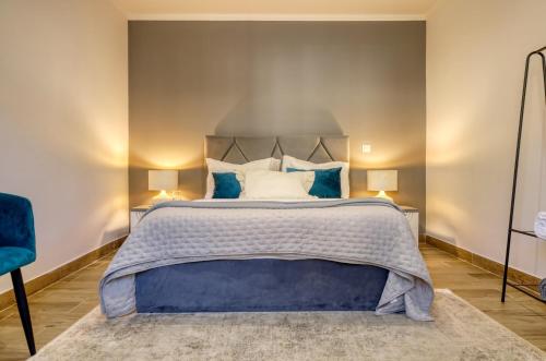 ein Schlafzimmer mit einem großen Bett und blauen Kissen in der Unterkunft Casa dos Anjos, a Home in Madeira in Lombo Galego