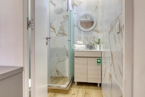 ein Badezimmer mit Dusche mit Spiegel und Waschbecken in der Unterkunft Casa dos Anjos, a Home in Madeira in Lombo Galego