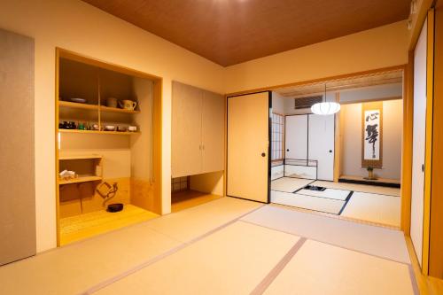 Una habitación con un pasillo con paredes amarillas y una puerta abierta. en 癒しの宿 古紗庵, en Minakami