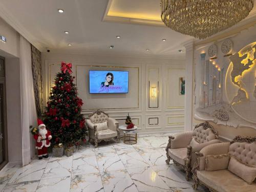a living room with a christmas tree and a tv at Maksima Premium in Samarkand