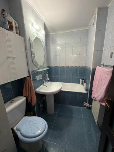a bathroom with a toilet and a sink and a tub at Apartament in Craiova in Craiova