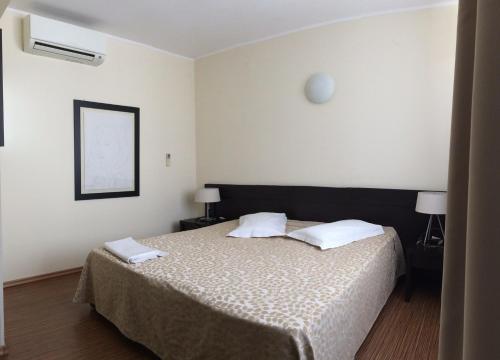 een slaapkamer met een bed met 2 witte kussens bij Pensiunea Play in Deva