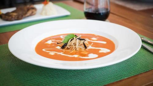 un plato blanco con un tazón de sopa en una mesa en Hotel Harrisson Guadalajara Centro, en Guadalajara