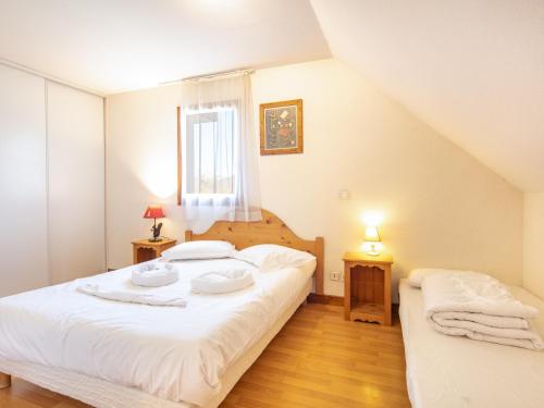 a bedroom with a bed with two plates on it at Résidence Vacancéole - Le Birdie in Giez