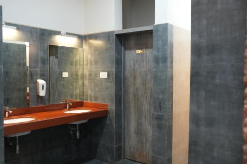 SeaFORT Beach Resort في Murūd: حمام عام فيه مغسلتين ومرآة