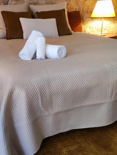 a bed with two rolls of toilet paper on it at Casa da Pedra - Alvados Porto de Mós, Leiria in Alvados