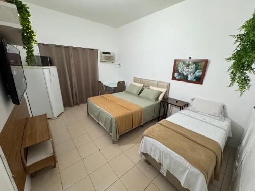 a room with two beds and a tv in it at Apartamento Centro Manaus 721 in Manaus