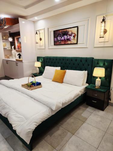 a bedroom with a large bed with a green headboard at Montana Lodges Murree in Murree