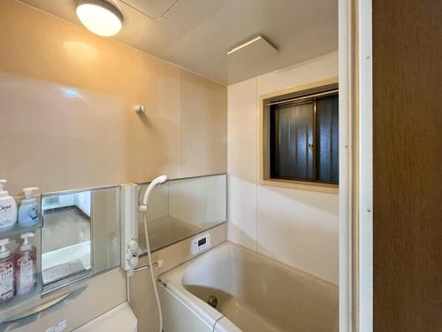 a bathroom with a bath tub and a sink at koto KAWASAKI in Kawasaki
