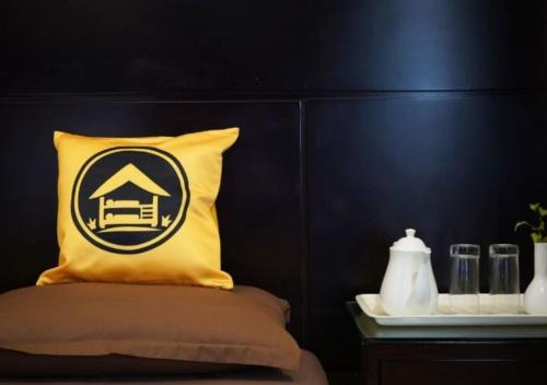Una cama con una almohada amarilla con una casa encima. en The Hosteller Delhi, International Airport, en Nueva Delhi