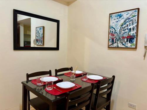 a dining room table with chairs and a mirror at The Infinity Condominium BGC at high Street in Sampong