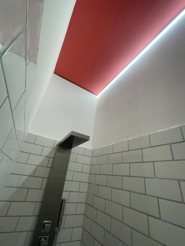 a bathroom with a red ceiling and white tiles at Residenze Rodari Altedo Affittacamere in Altedo