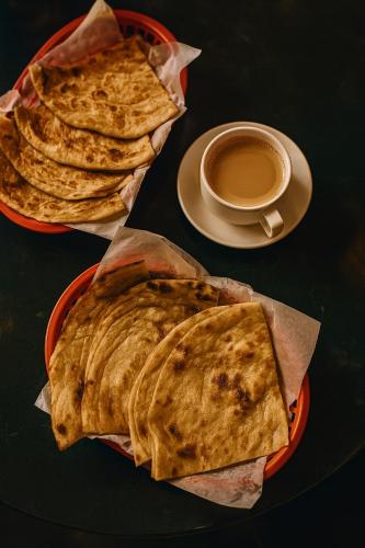 a table with two plates of food and a cup of coffee at Elysium Tower Luxury Studio & One Bedroom Apartments Opposite Centaurus Mall Islamabad in Islamabad