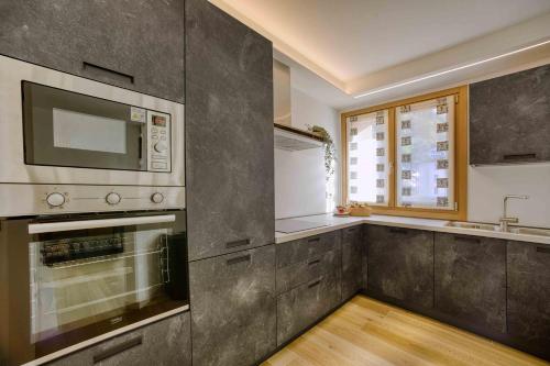 a kitchen with a stove and a microwave at La Corte Delle Dolomiti in Agordo
