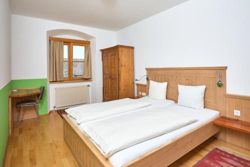 a bedroom with a large bed with white sheets at Gasthof Hotel Schiffsmeisterhaus in Ardagger Markt