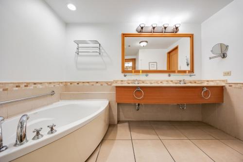 a bathroom with a tub and a mirror at Condado Lagoon by Otium in San Juan