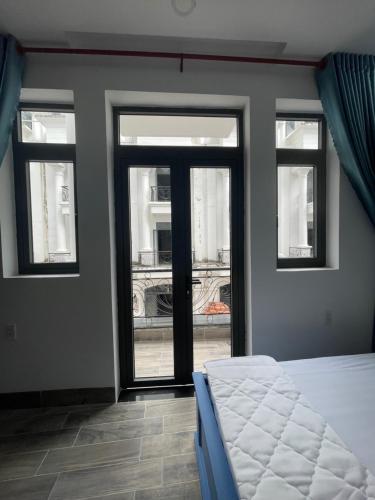 1 dormitorio con 3 ventanas y 1 cama en la parte delantera en Hotel CÂY THỊ, en Tây Ninh