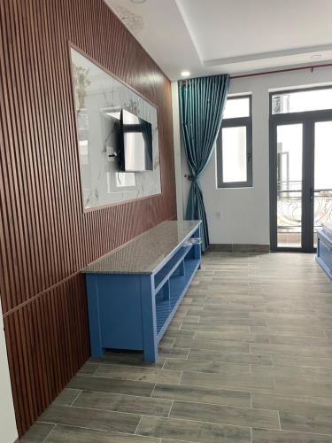 Habitación con escritorio azul y espejo. en Hotel CÂY THỊ, en Tây Ninh