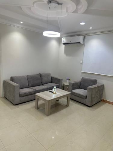 a living room with two couches and a table at شقق رحابة المكان للشقق المفروشه in Al Kharj