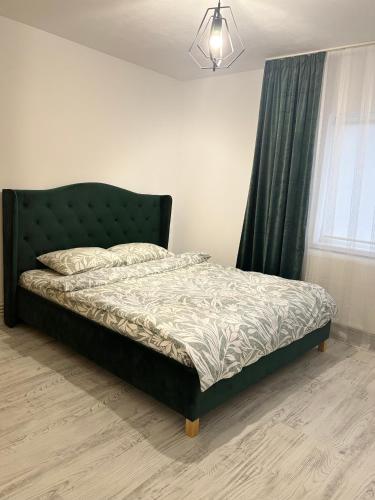 una camera da letto con letto con testiera verde e finestra di Amy's Home a Craiova