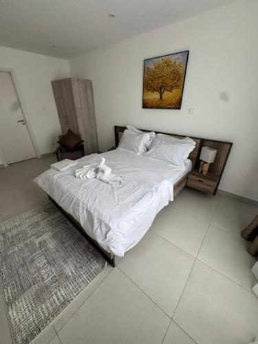 Un dormitorio con una cama grande con sábanas blancas. en Ebs legend at Bante apartments, en Accra