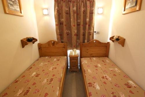 a small room with two beds and a curtain at Altineige Appartements VTI in Val Thorens