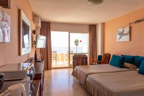 a hotel room with two beds and a balcony at Apartamentos La Jabega in Fuengirola