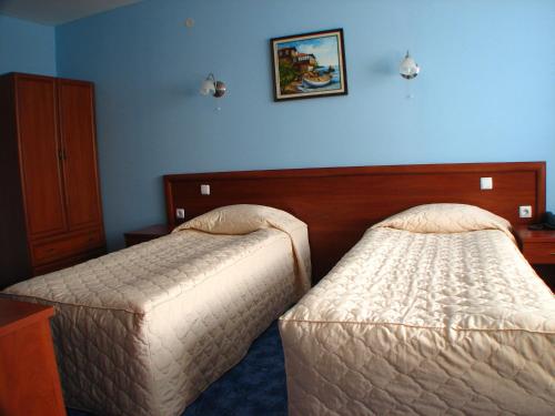 two beds in a hotel room with blue walls at Bariakov Family Hotel in Bansko