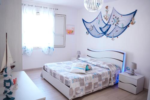een witte slaapkamer met een bed en een raam bij Villa del Marinaio in Mazara del Vallo