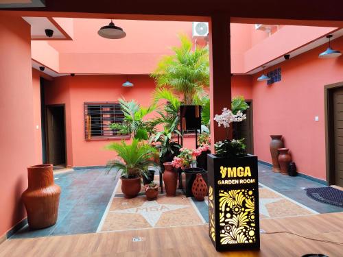 a lobby with potted plants in a building at RESIDENCE MGA HOTEL in Ouidah