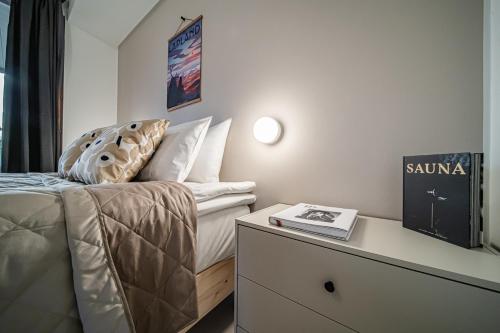 a bedroom with a bed and a table with a book at Aurora Gielas B5 Ski-in Ski-out, Mountain View by Aavalevi in Levi