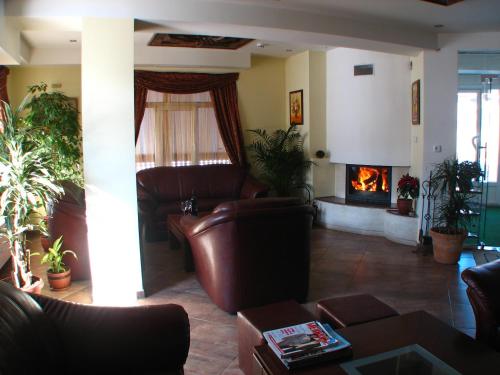 a living room with leather furniture and a fireplace at Bariakov Family Hotel in Bansko