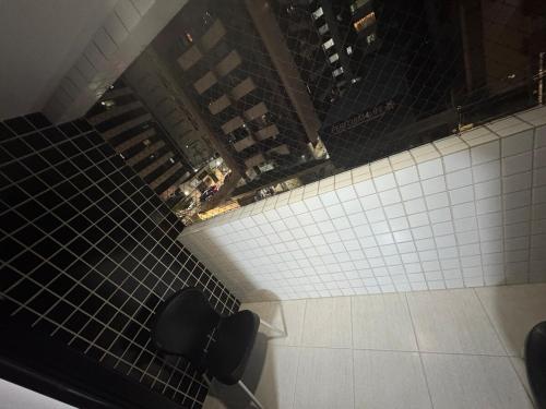 een bovenaanzicht van een betegelde gang met twee zitplaatsen bij Conforto na Ponta Verde in Maceió