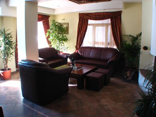 a living room with leather couches and a coffee table at Bariakov Family Hotel in Bansko