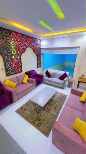 a living room with purple couches and a mosaic wall at منتحع سيتي لاند 3 in Taif