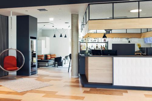 eine Bar mit einem roten Stuhl in einem Zimmer in der Unterkunft harry's home Telfs hotel & apartments in Telfs