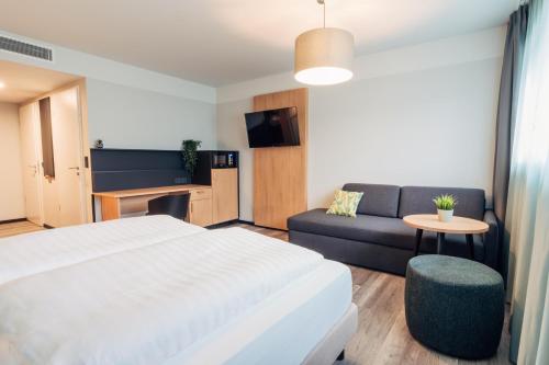 ザルツブルクにあるharry's home Salzburgのベッドとソファのあるホテルの部屋