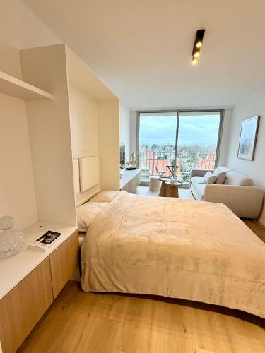 a bedroom with a large bed and a large window at Residentie Nieuwpoort in Nieuwpoort