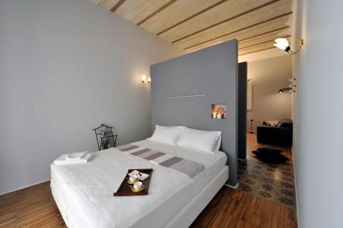 マテーラにあるLidia Chambres D'hotesのベッドルーム1室(白いベッド1台、トレイ付)