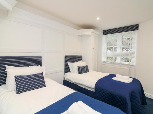 two beds sitting next to each other in a bedroom at 1 The Old Coach House in Dartmouth