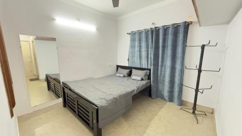 a small bedroom with a bed and a mirror at Casa Red Homestay in Chikmagalūr