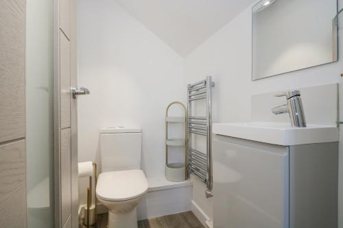 ein weißes Badezimmer mit Toilette und Waschbecken in der Unterkunft Cosy Retreat in Pool