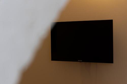 ein Flachbildfernseher, der an einer Wand hängt in der Unterkunft BM Rooms Innenstadt - Große Moderne City Apartments mit eigenem Bad im Herzen der Stadt in Bamberg