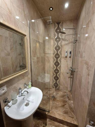 een badkamer met een wastafel en een douche bij B&B rooms in Tbilisi City