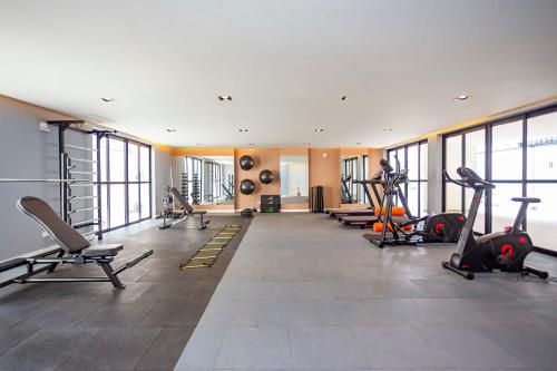 une salle de sport avec plusieurs tapis de course et vélos d'exercice dans l'établissement Edificio MUV Yogha, à Curitiba